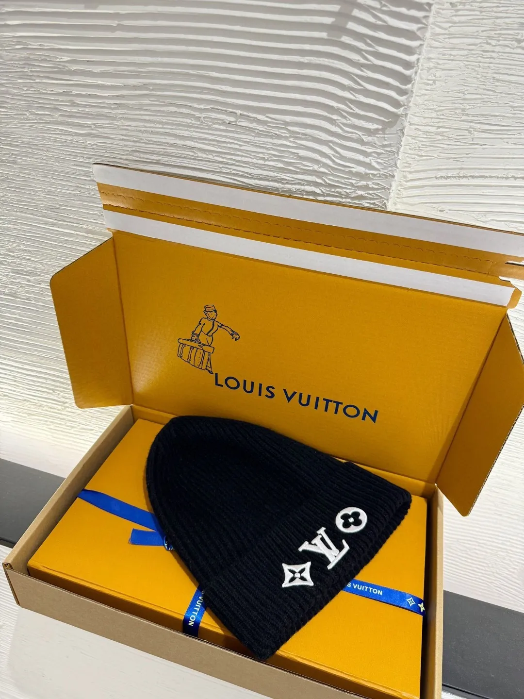 LOUIS VUITTON new embroidered wool cold hat ●Original version: 3800 purchase and development ●Item number: 1681973-A45 ●Fabric: wool blended fabric ●Technology: embroidery production ●Color: white/black ●Version: fitted version ●Description: This is LV The 2025 autumn and winter series logo embroidered knitted cold hat is made of 100% Italian virgin wool, woven with a 30-needle dense weaving process. The yarn twist reaches 600 twists/meter, which has both warmth and stiffness. The main body of the hat has a vertical grooved texture, which is elastically wrapped through fixed-spacing stitching techniques. The front logo of the hat uses three-dimensional appliqué technology, and the Monogram elements (quatrefoil, LV letters) are sewn with high-density embroidery threads of the same color. The edges are overlocked to prevent fuzzing and threading; the top of the hat is made of double-layer ribbing, which is durable and elastic and fits the ears. The finished product is shaped by high-temperature steam, and the three-dimensional shape of the hat is not easily deformed. The post-finishing process includes anti-static treatment, making it more comfortable for daily wear. The lining of the packaging is printed with the brand's classic "luggage maker" pattern, continuing the brand's retro luxury tone. The overall wiring is straight and delicate, the fabric is comfortable and soft, and the color is consistent without color difference. It can be matched with the same style to create a fashionable look and control various occasions. Customized accessories, complete with three standards, same style for men and women!